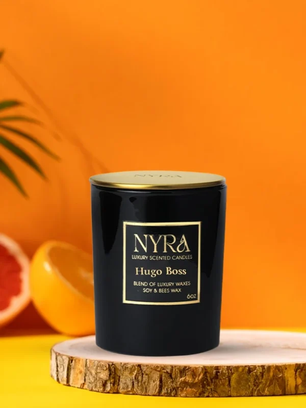 a black candle on a wood plate with oranges and leaves