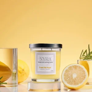 a candle in a glass jar next to lemons