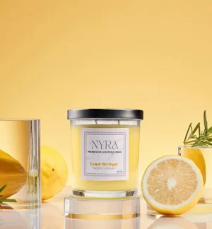 a candle in a glass jar next to lemons